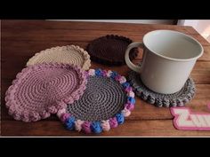 four crocheted coasters and a coffee cup on a table