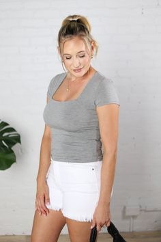 Upgrade your wardrobe with the Maya Square Neck Tee! This must-have top features a flattering fitted style, short sleeves, and a square neckline. Perfectly paired with your favorite wide leg or straight jeans for a chic and stylish look. Available in black, off white, sage, pebble, grey and chambray. Square Neck Tee Short Sleeves Care Instructions: Hand wash Fabric: 95% Rayon 5% Spandex Imported Size + Fit: small - 2 & 4 medium - 6 & 8 large - 10 & 12 Model Information: Beth is 5'7" and typicall Trendy Non-stretch Square Neck Tops, Square Fitted Top Solid Color, Casual Square Neck T-shirt For Everyday, Fitted Solid Color Square Top, Casual Square Neck T-shirt, Trendy Fitted Short Sleeve Top For Everyday, Versatile Stretch Square Neck Top, Everyday Summer T-shirt With Square Neck, Fitted Cotton T-shirt With Square Neck