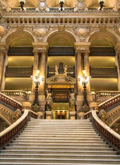 an ornate building with stairs and chandeliers