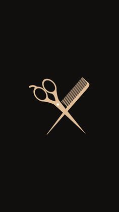 a pair of scissors and a comb on a black background