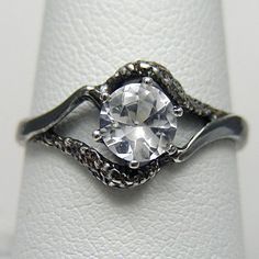 a white diamond ring sitting on top of a napkin