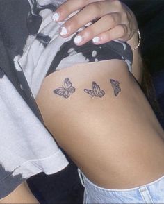 a woman's stomach with three butterflies tattooed on her lower back and right side