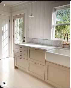 an empty kitchen with white cabinets and marble counter tops is seen in this image from the doorway