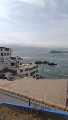 the ocean and buildings are next to each other in front of an overcast sky