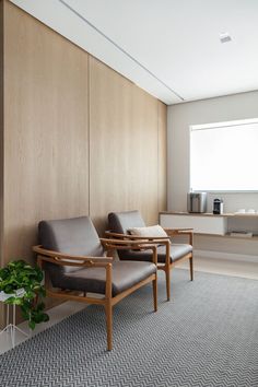 two chairs are sitting next to each other in a room with wood paneling on the walls