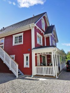 a red house with white trim and stairs