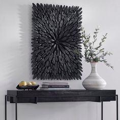 a black table topped with a vase filled with flowers