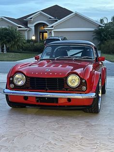 a red car parked in front of a house