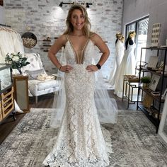 a woman in a wedding dress posing for the camera with her hands on her hips