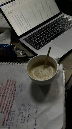 a cup of coffee sitting next to a laptop computer