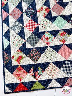 a blue and white quilt with red flowers on it