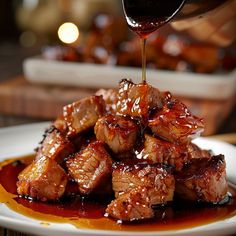 someone is pouring sauce over some meat on a plate