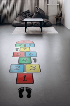 a living room with a couch, coffee table and floor graphics on the floor that spell out numbers