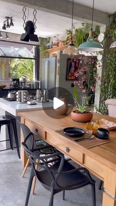 a kitchen with wooden table and chairs next to potted plants on the counter top