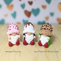 three small figurines sitting on top of a wooden table next to each other