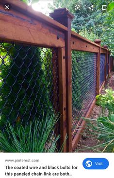 a wooden fence surrounded by plants and trees