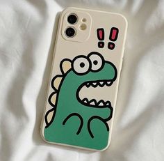 an iphone case with a cartoon character on it sitting on a white bed sheet and looking at the camera