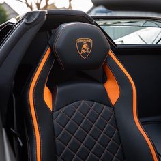 the interior of a sports car with black and orange stitching on the seat covers