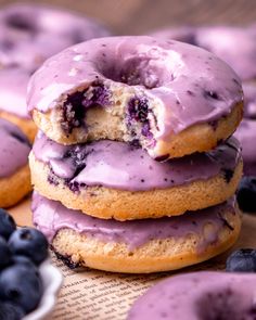 blueberry donuts are stacked on top of each other with one bite taken out