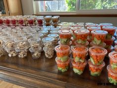 there are many plastic cups with vegetables in them on the table next to each other