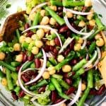 a salad with beans and onions on a glass plate