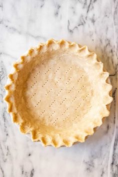 an uncooked pie crust on a marble surface