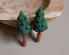 two miniature trees are sitting on a table