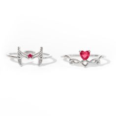 two rings with hearts on them sitting next to each other in front of a white background