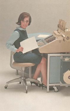 a woman sitting at a desk with a computer