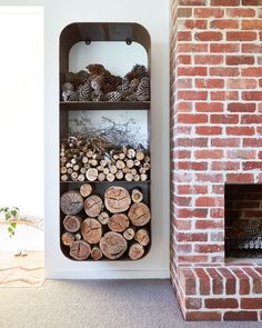 a fire place with logs stacked on top of it next to a wall mounted fireplace