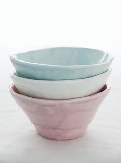 three bowls stacked on top of each other in pastel blue, pink and white