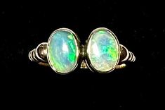 "Beautiful double natural Australian opal ring, 14K gold, handmade, unique, and with obvious inspiration from ancient gold work. The opals are bezel set 8mm X 6mm, and 7.85mm X 6mm, flanked by gold worked in a rope detail that terminates in accenting gold balls. The ring is a size 5 3/4, and it is fully marked for \"14K\" as shown. You may wonder how it is that we determine whether the opals are Australian vs Mexican or Ethiopian. Using a high-power black light, the opals both show fluorescence Heirloom Opal Cabochon Ring, Heirloom Cabochon Opal Ring, Heirloom Opal Ring Collectible, Heirloom Style Collectible Opal Ring, Unique Hallmarked 14k Gold Opal Ring, 14k Gold Hallmarked Opal Ring, Unique Hallmarked Opal Ring In 14k Gold, Unique 14k Gold Hallmarked Opal Ring, Green Opal Cabochon Ring