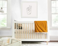 a baby's room with a white crib and yellow blanket