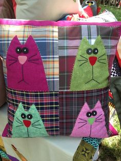 a colorful patchwork bag with cats on it's front and back sides, sitting in the grass