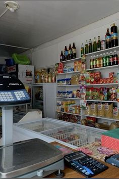 a store filled with lots of different types of food and drinks on shelves next to a cash register