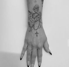 a woman's hand with tattoos and rings on her fingers is shown in black and white