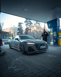 a man taking a photo of a car at a gas station