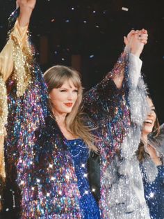 taylor swift performing on stage with confetti in the air and her arms up