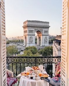 an outdoor table with food and drinks on it in front of the arc de trio triumph