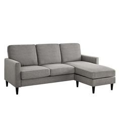 a gray sectional couch sitting on top of a white floor