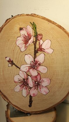 a piece of wood with pink flowers painted on it