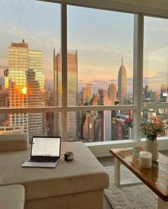 a laptop computer sitting on top of a table in front of a living room window