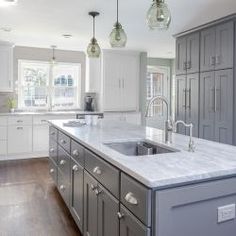 a large kitchen with an island in the middle and lots of cabinets on both sides