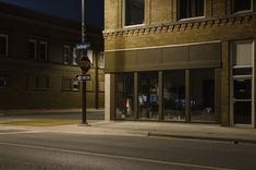 an empty city street at night with no one on the sidewalk or in front of it