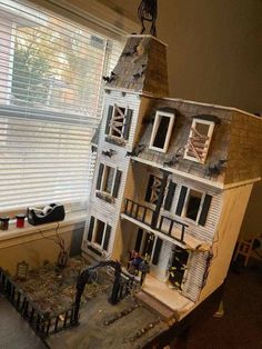 a doll house is shown in front of a window with the roof ripped off and broken