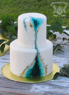 a three tiered cake with blue and white icing on it's side