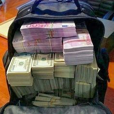 a suitcase filled with money sitting on top of a wooden table