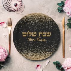 a black and gold plate with the word hebrew family written on it, surrounded by pink flowers