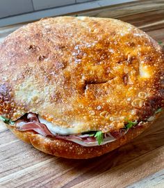 a large sandwich sitting on top of a wooden cutting board