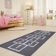 a child's bedroom with a rug that has numbers and letters drawn on it